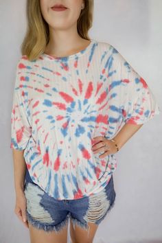 This is a white short sleeve knit top with red and blue tie dye swirl. The model is wearing a size small. Tie Dye Short Sleeve Top For Summer, Casual Stretch Tops For 4th Of July, Casual Tops For 4th Of July, Casual Tie Dye Tops For Day Out, Casual Multicolor T-shirt For 4th Of July, Cotton Tie Dye Tops For A Day Out, Red Summer T-shirt For Day Out, Trendy Stretch Tie Dye Tops, Red T-shirt For Summer Day Out