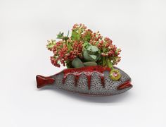 a ceramic fish planter with succulents and flowers in it's mouth