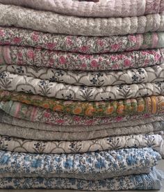 a stack of old quilts sitting on top of a table