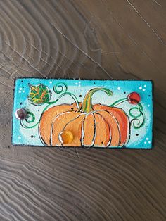 a painted pumpkin sitting on top of a wooden table