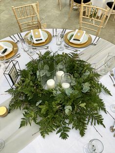 the table is set with candles and greenery