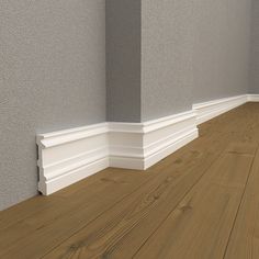 an empty room with wood flooring and white trim on the walls, along with a gray wall