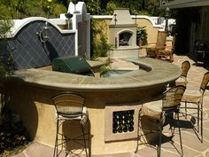 an outdoor table with chairs around it