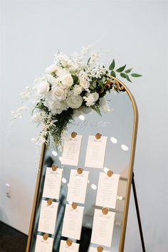 a mirror with seating cards and flowers on it