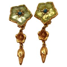 KENZO vintage gold tone floral dangling earrings (clip-on) featuring a resin flower top, gold tone flower and blossom. Embossed KENZO Paris Made in France. Indicative measurements : height approx. 6 cm (2.36 inches) / max. width approx. 2.5 cm (0.98 inch). Weight per earring : approx. 11 grams. Materials : Gold tone metal hardware / Resin / Glass. NOTES - This is a preloved vintage item, therefore it might have imperfections. - Colors may differ slightly from actual product appearance due to dif Vintage Gold Flower Clip-on Earrings, Vintage Gold Earrings With Flower Charm, Vintage Green Flower Earrings, Vintage Clip-on Flower Earrings, Kenzo Paris, Pink Drink, Flower Top, Pink Drinks, Vintage Clip