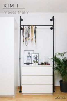 a white dresser sitting in front of a wall mounted coat rack