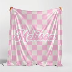 a pink and white checkered wall hanging with the word nelson on it's side