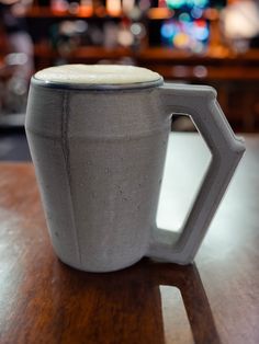 a gray mug sitting on top of a wooden table