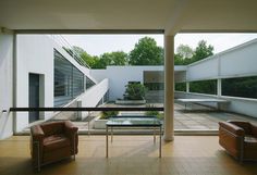 two brown chairs sitting in front of a glass table