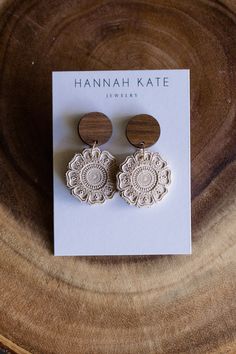 the earrings are made from wood and have an intricate lace design on each earring