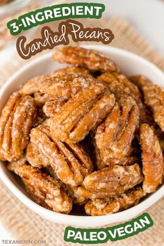 a bowl filled with candied pecans on top of a table