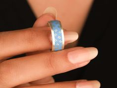 a woman's hand wearing a ring with an arrow pattern on the inside of it