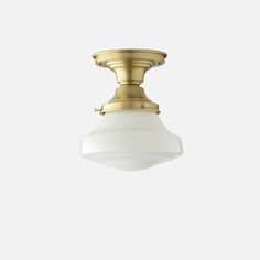 a brass ceiling light with a white glass shade