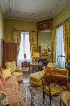 a living room filled with lots of furniture and walls covered in gold wall coverings