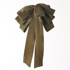 an olive green bow tie hanging from a white wall