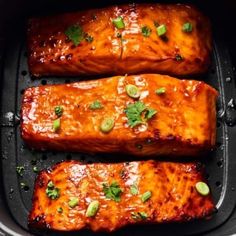 three salmon fillets in a slow cooker ready to be cooked with sauce and seasonings