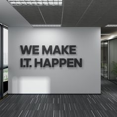 the words we make it happen are displayed on a wall in an empty office space