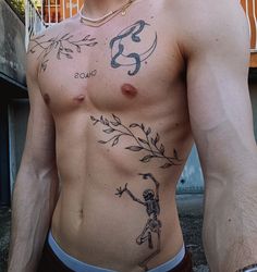 a shirtless man with tattoos on his chest