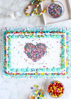 a birthday cake decorated with sprinkles and a heart