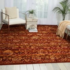 a living room area with a chair, rug and potted plant on the floor