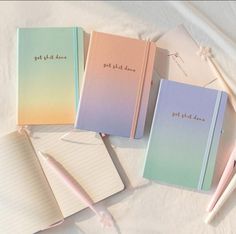 four notebooks with writing on them sitting next to a pen and an eraser