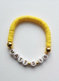 a yellow and white beaded bracelet with the word matte on it's side