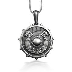 a necklace with an image of a shield and two swords on the inside of it