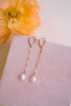 Add a touch of classic, yet glam style with our Gwen Pearl Drop Earrings! These delicate dangle earrings feature an elegant and minimalist design that effortlessly elevates your look! Adorned with freshwater pearls, they're sure to make you stand out. FEATURES Materials: 14K Gold Filled Chain, Pavé Cubic Zirconia, Freshwater Pearls Dimensions: 2.5" drop Elegant Pearl Pendant Earrings, Elegant Bridal Earrings With Pearl Charm, Timeless Dangle Bridal Earrings For Wedding, Elegant Bridal Pearl Earrings With Charm, Timeless Pearl Charm Drop Earrings, Elegant Dangle Pearl Charm Jewelry, Elegant Crystal Drop Earrings, Elegant Teardrop Earrings With Pearl Charm For Gift, Elegant Dangle Pearl Drop Jewelry