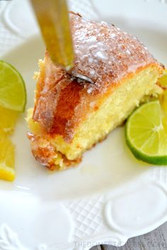 a slice of cake on a white plate with limes