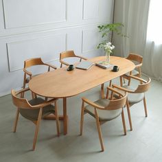 a wooden table with chairs around it and a laptop on the table next to it