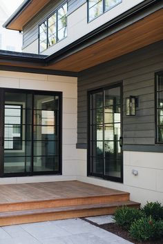 an outside view of a house with wood steps and glass doors on the front door