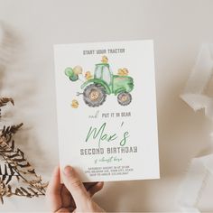 a hand holding up a card with a tractor on it and the words, just put it in near me's second birthday