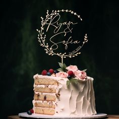 a wedding cake with white frosting and berries on top, sitting on a wooden table