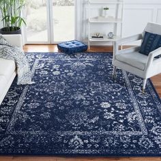 a living room with blue rugs and white furniture