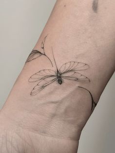 a small dragonfly tattoo on the wrist