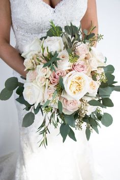 a bridal holding a bouquet of white and pink flowers