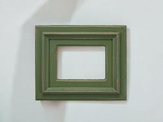 a green square frame hanging on the wall