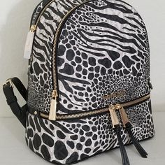 Brand New Department Store Quality Authentic Michael Kors Rhea Zip Medium Monogram Backpack In Black/Vanilla Animal Print. The Bag Is Crafted From The Top Quality Water And Stain Resistant Monogrammed Pvc With Leather Trim, And Elegantly Detailed With Gold Tone Hardware. This Backpack With Zippered Top Bag Is Perfect For All Your Busy Weekdays And Leisure Weekends And Features A Tech-Friendly Padded Internal Pocket! Your Brand New Authentic Bag In The Original Packaging Will Come Wrapped In Whit Trendy Michael Kors Bag With Zipper Closure, Michael Kors Backpack With Zipper Closure For On-the-go, Designer Michael Kors Bag With Zipper Closure, Designer Michael Kors Backpack With Zipper Closure, Michael Kors Rhea Backpack, Slim Backpack, Black White Logo, Logo Animal, Monogram Backpack