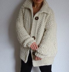 a woman standing in front of a white wall wearing a jacket and leggings