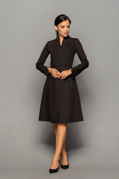 Elegant cocktail dress featuring high neck collar, a-line silhouette, and long sleeves. - high neck (stand collar) - trapeze skirt with inverted front pleat  - long sleeves with elegant cuffs - knee length (midi) - a line silhouette - the dress is decorated with high-quality metal buttons  Perfect as party, modest bridesmaid or elegant office dress. Seasons: autumn, winter, spring. Color: Black  Fiber: viscose - 60%, elastan - 5%, polyester - 35%  Concealed back zipper closure For Size 2 US / 36 Dresses With Sleeves Elegant, Cocktail Dress Classy Evening, Elegant Purple Dresses, Formal Wedding Guest Dresses, Elegant Cocktail Dresses, Wedding Guest Dresses With Sleeves, Marsala Dress, Unique Cocktail Dresses, Stand Collar Dress