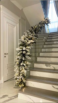 a christmas garland is hanging on the stairs