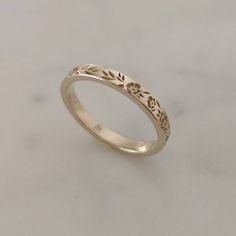 a gold wedding ring with leaves on it