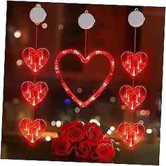 a window decorated with red roses and lighted hearts