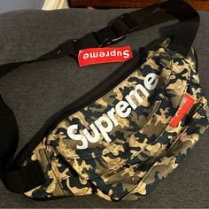 Rare Supreme Waist Bag With Functionality And Style. The Supreme Waist Bag Features Two Pockets On The Front. The Front Pocket Has A Zip Closure, An Embossed Supreme Logo With White Lining, Slightly Above The Front Pocket Is The Main Compartment, Also Secured By A Zip. It Opens To A Spacious Storage Unit With Soft Nylon Dividers To Help Organize The Bag's Contents. The Waist Strap Of This Carry-On Is Embellished By A Plastic Clasp And Metallic Joins That Allow For Easy Length Adjustment. Its Oli Functional Satchel Bag For Streetwear, Streetwear Satchel Bag With Zipper Pocket, Designer Shoulder Bag With Pockets For Daily Use, Streetwear Shoulder Bag With Zipper Pocket, Daily Use Logo Pouch Bag, Luxury Bags For Outdoor Activities, Functional Streetwear Shoulder Bag, Black Logo Bags For Outdoor Activities, Casual Bags With Logo For Outdoor Activities