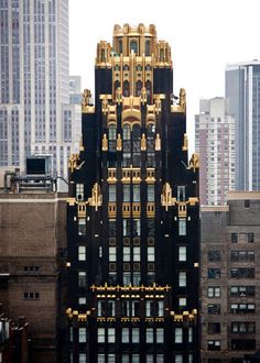 a very tall building with many windows and gold decorations on it's sides in the city