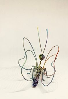 a wire sculpture of a butterfly on a white background