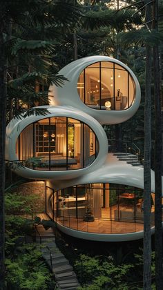 two circular houses in the woods with stairs leading up to them and windows on each floor