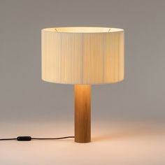 a lamp that is on top of a white surface with a cord attached to it