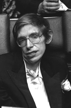 black and white photo of man in suit sitting down