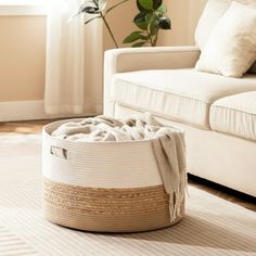 a living room with a white couch and a basket on the floor next to it